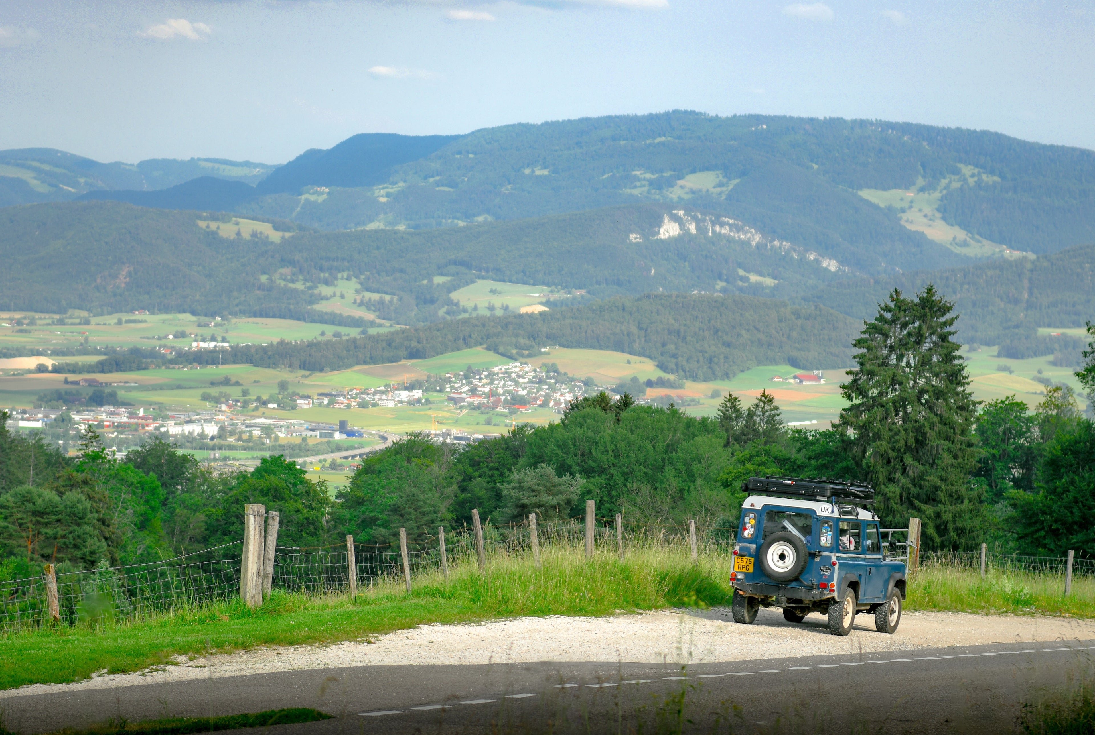Blue vintage truck on a road with a scenic mountain landscape in the background